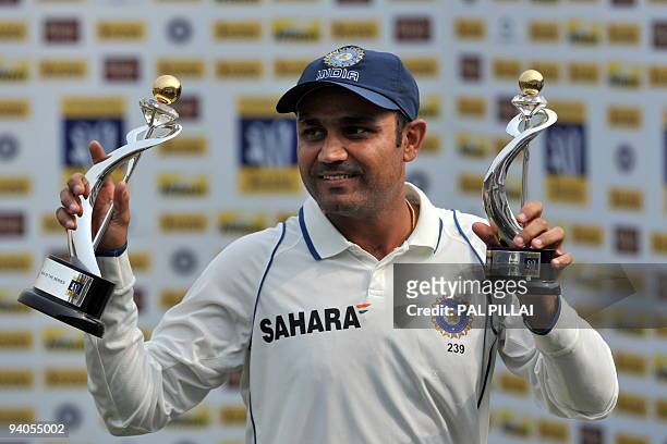 Indian cricketer Virendra Sehwag shows the trophy after winning "Man of the match" and "Man of the series" after his team won on the final day of the...
