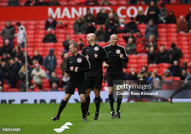 Match officials, Marc Perry, Bobby Madley and Mick McDonough warm up prior to the Premier League match between Manchester United and Swansea City at...