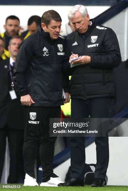 Alan Pardew, Manager of West Bromwich Albion makes notes with John Carver during the Premier League match between West Bromwich Albion and Burnley at...