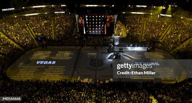 Names of the 58 victims of the October 1, 2017 mass shooting in Las Vegas are projected on the ice as the Vegas Golden Knights hang a banner in the...