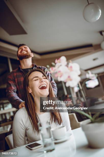 young male massaging her girlfriend while she drink morning coffee - girlfriend massage stock pictures, royalty-free photos & images