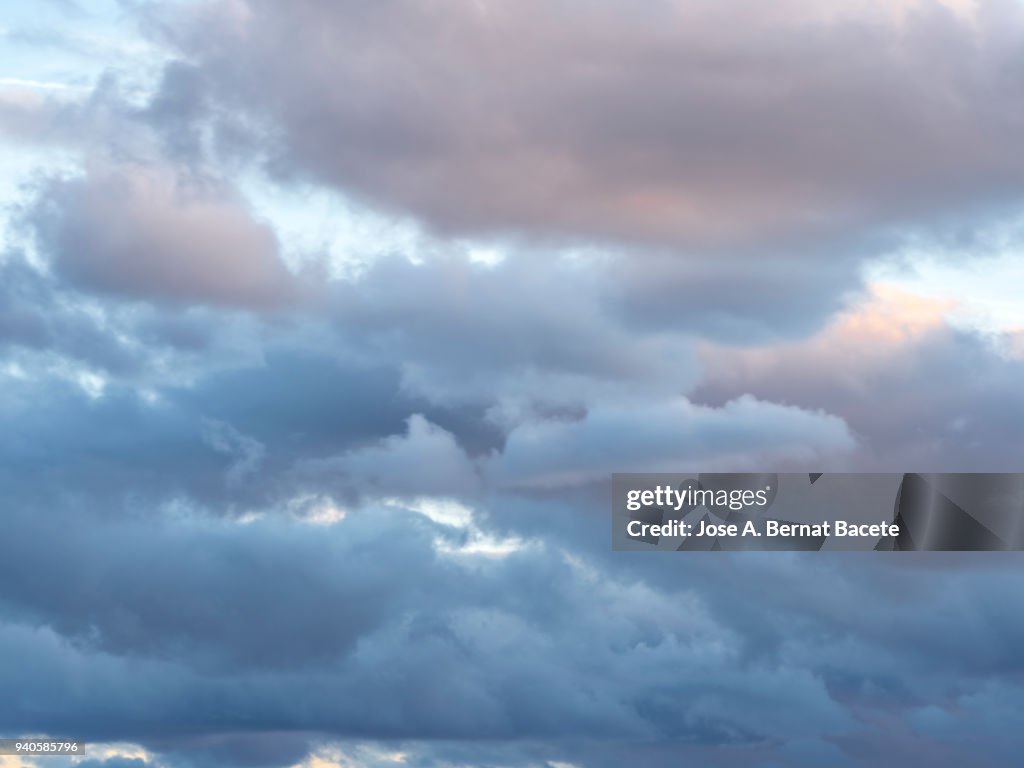 Full frame of the low angle view of clouds of colors in sky during sunset with crepuscular light. Valencian Community, Spain