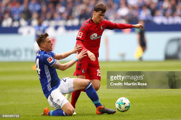 Bastian Oczipka of Schalke fights for the ball with Pascal Stenzel of Freiburg during the Bundesliga match between FC Schalke 04 and Sport-Club...