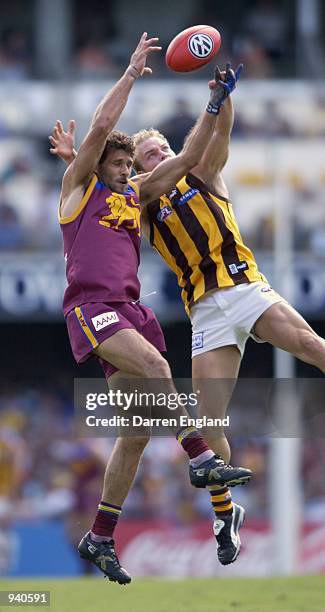 Darryl White of Brisbane has his mark spoiled by Lance Picioane of Hawthorn during the round two AFL match between the Brisbane Lions and the...