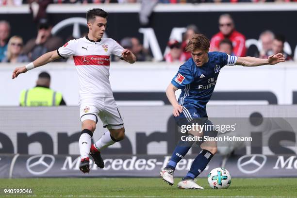 Gotoku Sakai of Hamburg is chased by Erik Thommy of Stuttgart during the Bundesliga match between VfB Stuttgart and Hamburger SV at Mercedes-Benz...