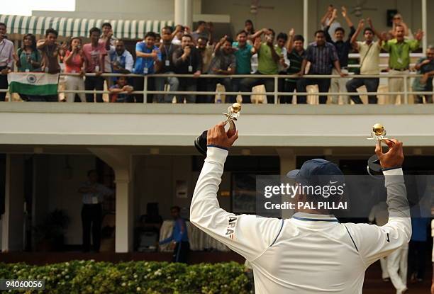 Indian cricketer Virendra Sehwag shows his "Man of the match" and "Man of the series" trophies to admirers after his team won on the final day of the...