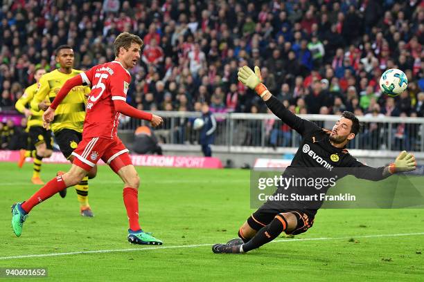 Thomas Mueller of Bayern Muenchen (l scores a goal past goalkeeper Roman Buerki of Dortmund to make it 3:0 during the Bundesliga match between FC...