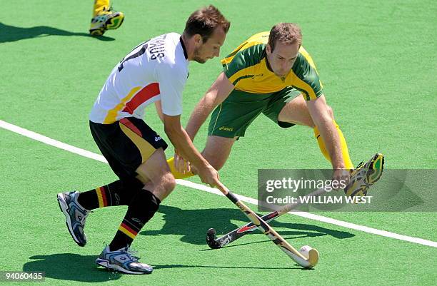 Australian player Mark Knowles challenges Germany's Matthias Witthaus in the final of the Champions Trophy field hockey tournament in Melbourne on...