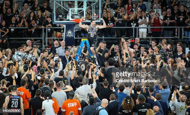 Melbourne United captain Chris Goulding celebrates with fans as he cuts down the net after winning game five of the NBL Grand Final series between...