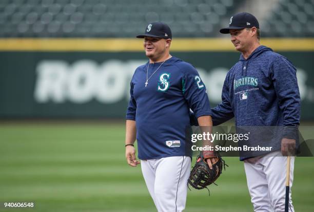 Seattle Mariners manager Scott Servais, right, pats on the back Daniel Vogelbach of the Seattle Mariners before a game against the Cleveland Indians...