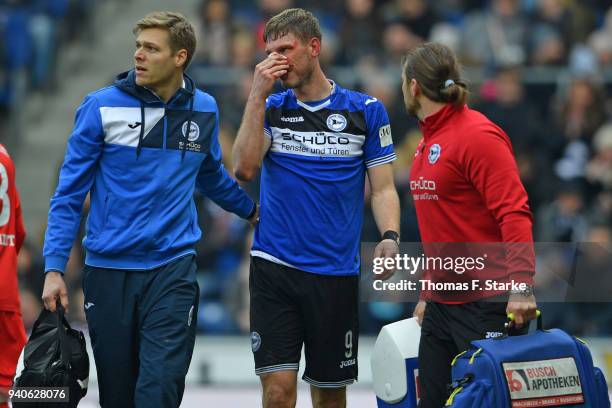 Fabian Klos of Bielefeld receives medical treatment by doctor Stefan Budde and physiotherapist Michael Schweika during the Second Bundesliga match...