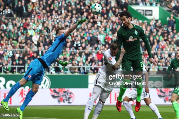 Ishak Belfodil of Bremen and Lukas Hradecky and Marco Russ of Frankfurt compete for the ball during the Bundesliga match between SV Werder Bremen and...