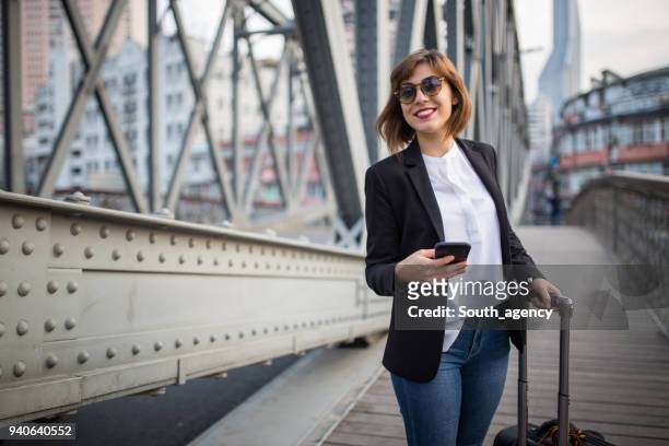 mooie vrouw staande op de brug met koffer - business woman suitcase stockfoto's en -beelden