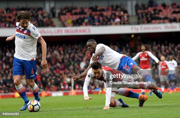 Mesut Ozil of Arsenal is fouled in the box by Bruno Martins Indi of Stoke City and a penalty is awarded during the Premier League match between...