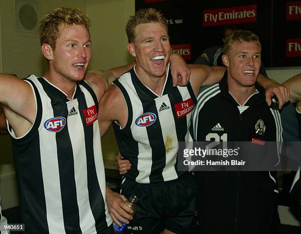 Ben Johnson, Nathan Buckley and Tarkyn Lockyer for Collingwood sing the team song in the rooms, after the Round 2 AFL Match between the Collingwood...