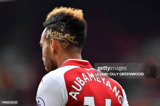 Arsenal's Gabonese striker Pierre-Emerick Aubameyang dedicates his latest hairstyle to his grandmother who passed away last week, during the English...