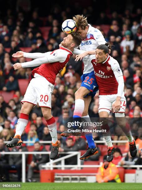 Peter Crouch of Stoke City wins a header over Shkodran Mustafi of Arsenal and Hector Bellerin of Arsenal during the Premier League match between...