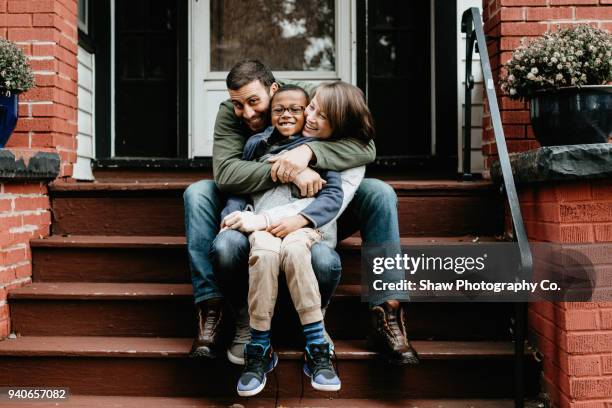 multi racial family photos with adoptive son big hug - adoption stockfoto's en -beelden