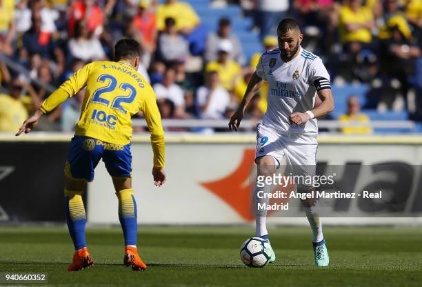 Karim Benzema of Real Madrid is challenged by Ximo Navarro of UD Las Palmas during the La Liga match between UD Las Palmas and Real Madrid at the...