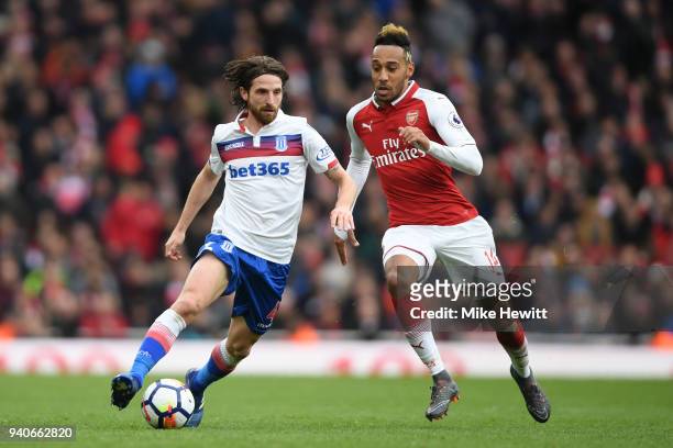 Joe Allen of Stoke City is challenged by Pierre-Emerick Aubameyang of Arsenal during the Premier League match between Arsenal and Stoke City at...