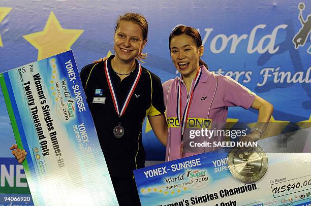 Women's singles champion Wong Mew Choo of Malaysia smiles next to runner-up Juliane Schenk of Germany during the award ceremony at the Badminton...