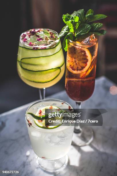 two cocktails in sun on marble benchtop in bar - cucumber cocktail stock pictures, royalty-free photos & images