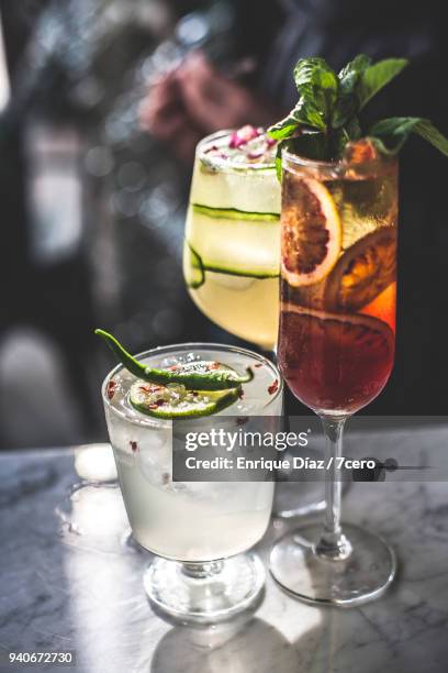 three cocktails on marble benchtop in bar - cucumber cocktail stock pictures, royalty-free photos & images