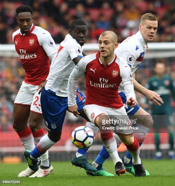 Jack Wilshere of Arsenal takes on Badou Ndiaye and Ryan Shawcross fo Stoke during the Premier League match between Arsenal and Stoke City at Emirates...