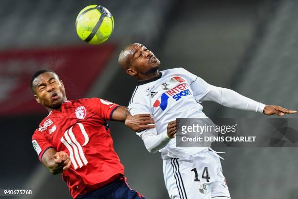 Lille's Ivorian defender Kouadio-Yves Dabila and Amiens' Congolese midfielder Gael Kakuta go for a header during the French L1 football match played...
