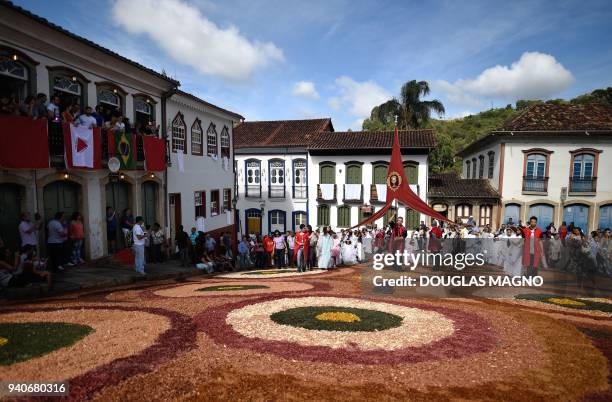 Catholics walk over a sawdust rug during an Easter Sunday procession representing the resurrection of Christ, in the Brazilian historic city of Ouro...