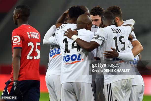 Amiens's players celebrates after opening the scoring during the French L1 football match played behind closed doors on April 1, 2018 at the grand...