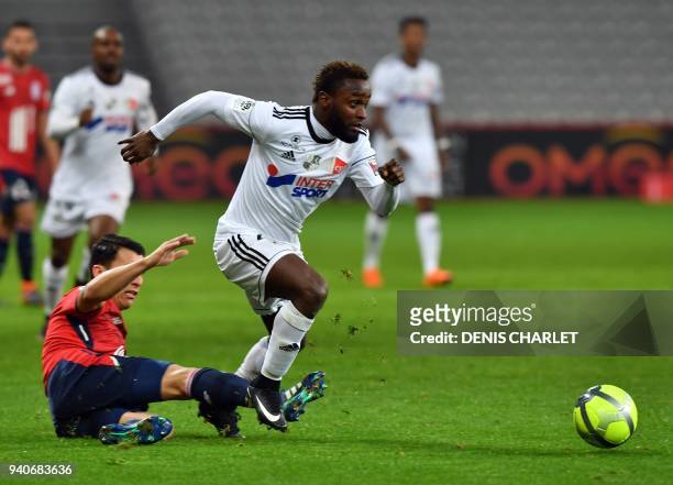 Amiens' Colombian forward Stiven Mendoza outruns Lille's Paraguayan defender Junior Alonso during the French L1 football match played behind closed...