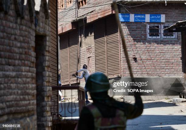 Kashmiri protester throw stones towards an Indian policeman during clashes in Srinagar, Indian administered Kashmir. Eight suspected militants and 2...