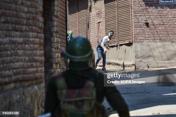 Kashmiri protester throw stones towards an Indian policeman during clashes in Srinagar, Indian administered Kashmir. Eight suspected militants and 2...