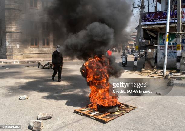 Kashmir protester stands next burning tyres during a protest in Srinagar, Indian administered Kashmir. Eight suspected militants and 2 Indian army...