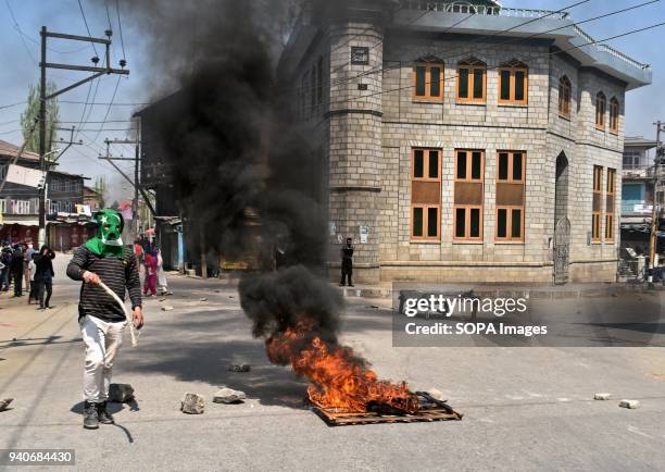 Kashmir protester stands next burning tyres during a protest in Srinagar, Indian administered Kashmir. Eight suspected militants and 2 Indian army...