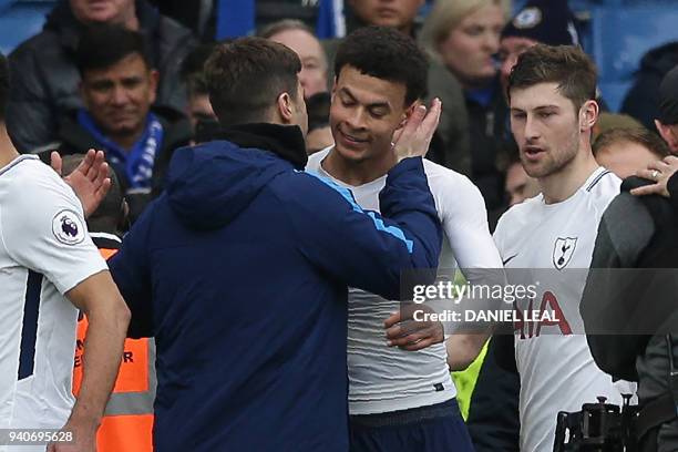 Tottenham Hotspur's English midfielder Dele Alli is congratulated by Tottenham Hotspur's Argentinian head coach Mauricio Pochettino after the English...