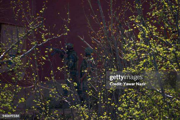 Indian military forces take position towards the houses where rebels have take refuge and are fighting with them during a gun battle between Indian...