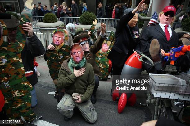 Protesters, wearing masks of Donald Trump, Vladimir Putin and Kim Jong-un, attend the April Fools Day Parade by Trump Tower on the Fifth Avenue in...