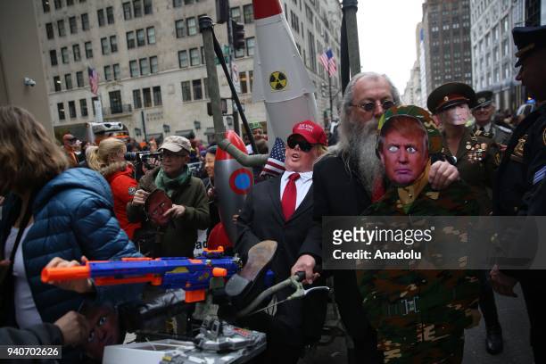 Protesters, wearing masks of Donald Trump and Vladimir Putin, attend the April Fools Day Parade by Trump Tower on the Fifth Avenue in New York City,...