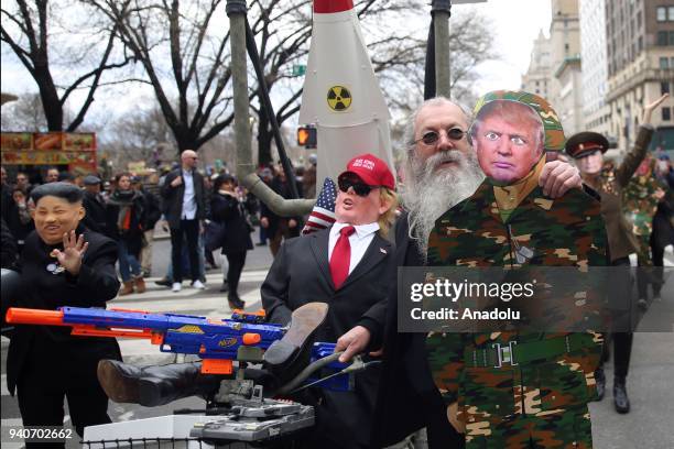 Protesters wearing masks mocking Donald Trump, Vladimir Putin and Kim Jong-un attend the April Fools Day Parade byTrump tower on the Fifth Avenue in...