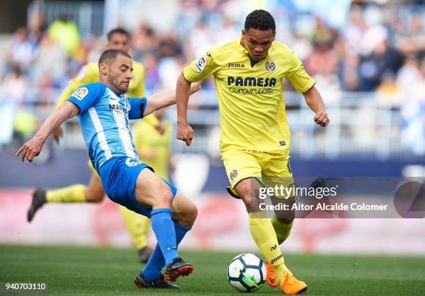 Carlos Bacca of Villarreal CF being followed by Medhi Lacen of Malaga CF during the La Liga match between Malaga and Villarreal at Estadio La...