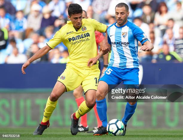 Rodrigo Hernandez of Villarreal CF competes for the ball with Medhi Lacen of Malaga CF during the La Liga match between Malaga and Villarreal at...