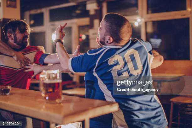 group of men fighting in sports bar - hooligans stock pictures, royalty-free photos & images