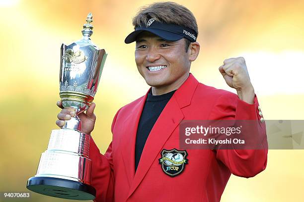 Shigeki Maruyama of Japan poses with a trophy after winning the Nippon Series JT Cup at Tokyo Yomiuri Country Club on December 6, 2009 in Tokyo,...