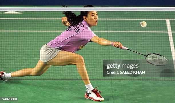Wong Mew Choo of Malaysia reaches for the shuttlecock to return to Juliane Schenk of Germany during women's singles final at the Badminton World...