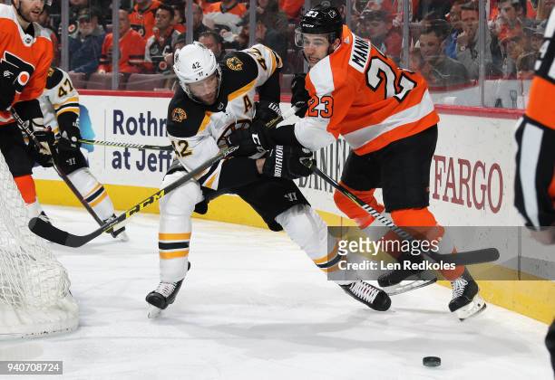 Brandon Manning of the Philadelphia Flyers battles for the loose puck behind the net with David Backes of the Boston Bruins on April 1, 2018 at the...