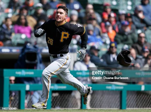 Adam Frazier of the Pittsburgh Pirates loses his helmet as he rounds third base to score against the Detroit Tigers from first base on a double by...