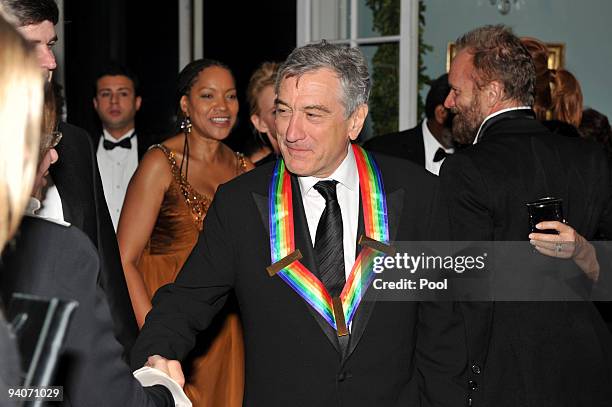 Robert De Niro shakes hands with an unidentified guest after he and his fellow 2009 Kennedy Center honorees posed for the formal group photo...