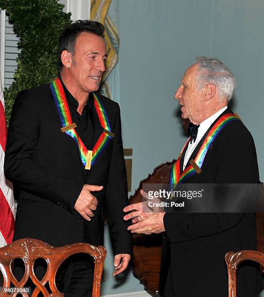 Kennedy Center honorees Bruce Springsteen, left, and Mel Brooks, right, engage in conversation as they prepare to pose with the other honorees for...